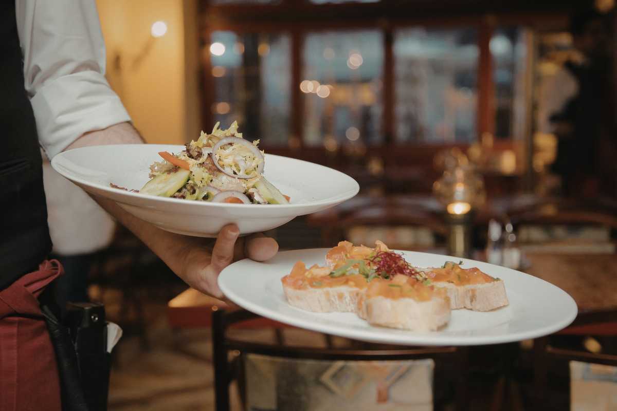 Dettaglio di un piatto di busiate con bottarga su tavolo rustico, ambiente di una trattoria tradizionale di Favignana